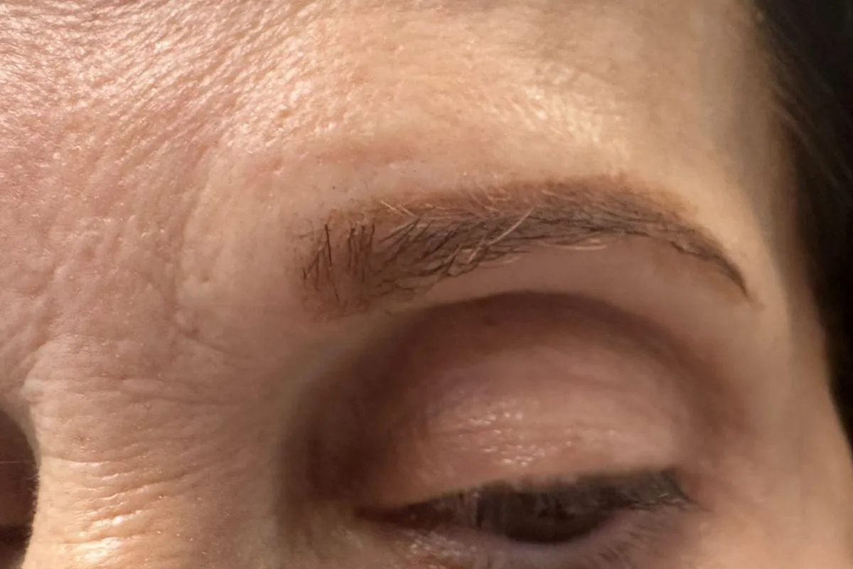 Before: a client's sparse, light brown eyebrow with gaps