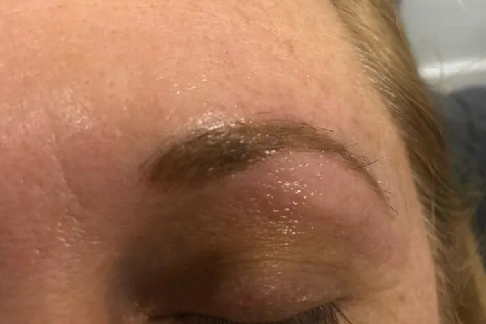 After: the same brow immediately after the procedure, reshaped in a soft, warm brown
